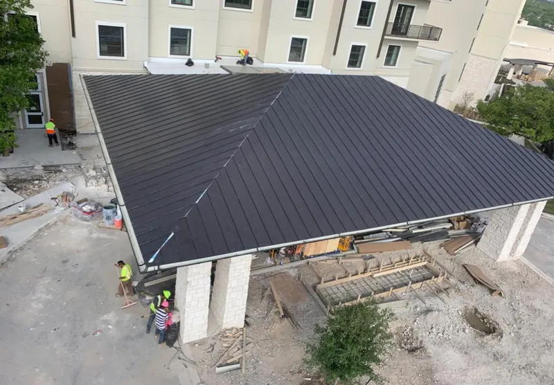 Metal roofing installation team working on a commercial building in Stamford